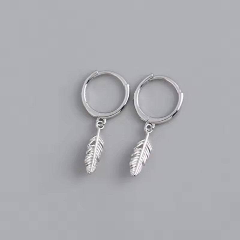 Small silver hoop earrings with a dangling silver feather on each earring
