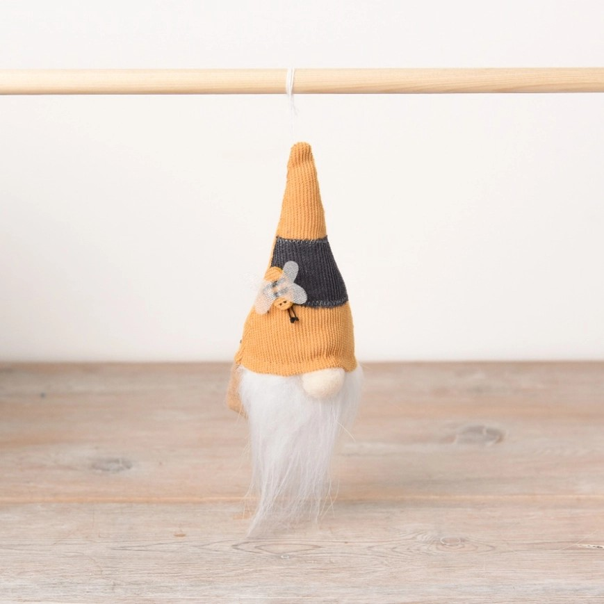 Gonk decoration on a hanger with a white fluffy beard and a pointy had with thick yellow and black stripes and a small fabric bee decoration on the hat. 