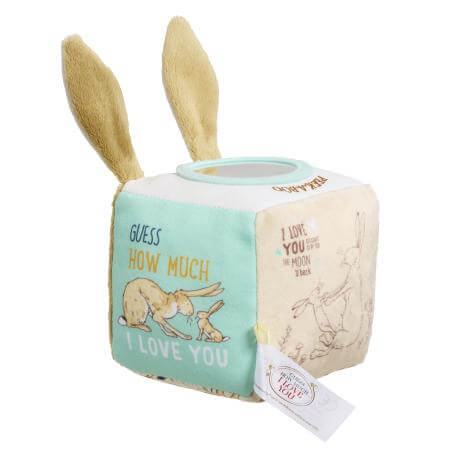 Children's soft toy activity cube with bunny ears and differently designed sides on a white background