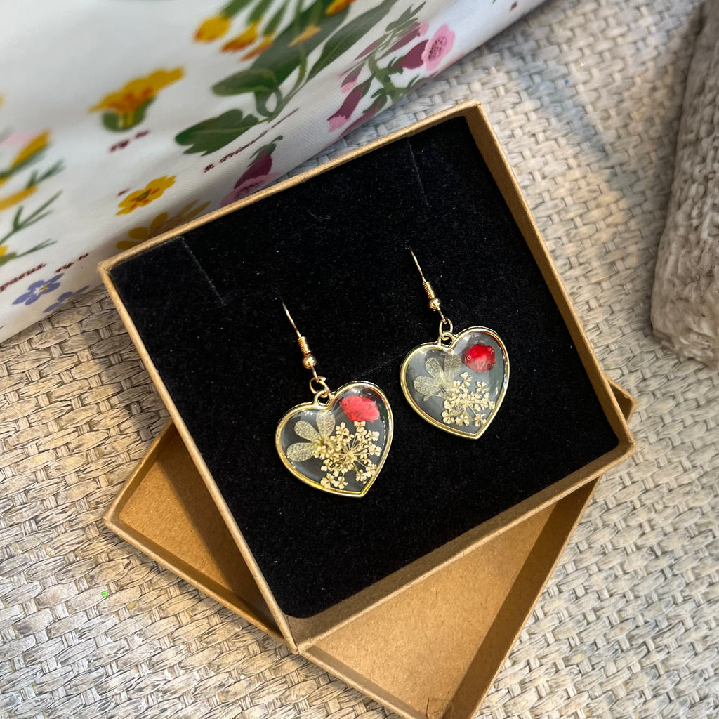 Gold, heart shaped drop earrings filled with real flowers in resin