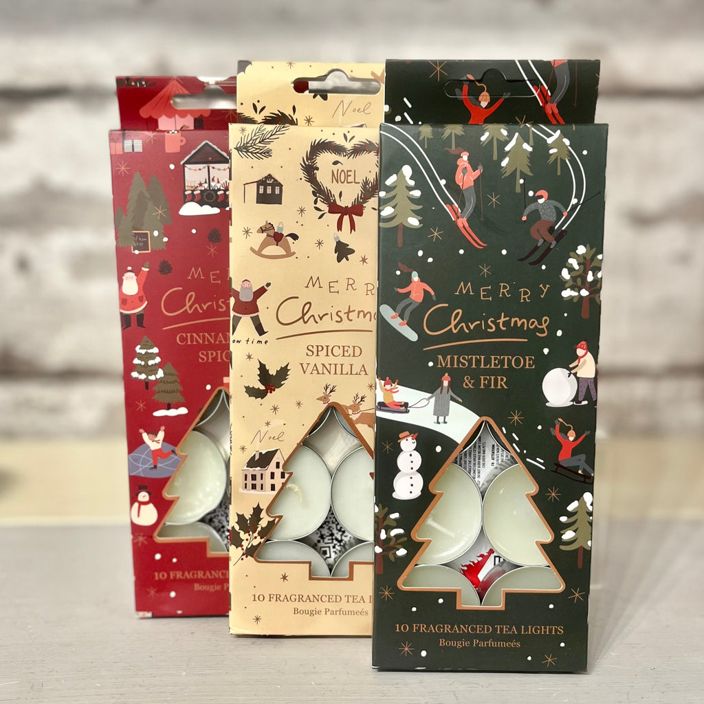 Three Christmas-themed tea light packages on a neutral background