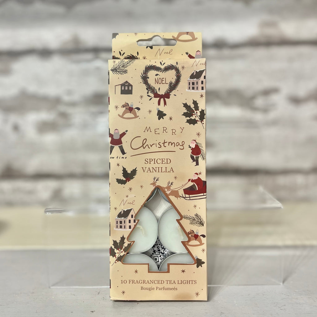 Pack of spiced vanilla tea lights with Christmas-themed packaging on a wooden surface.