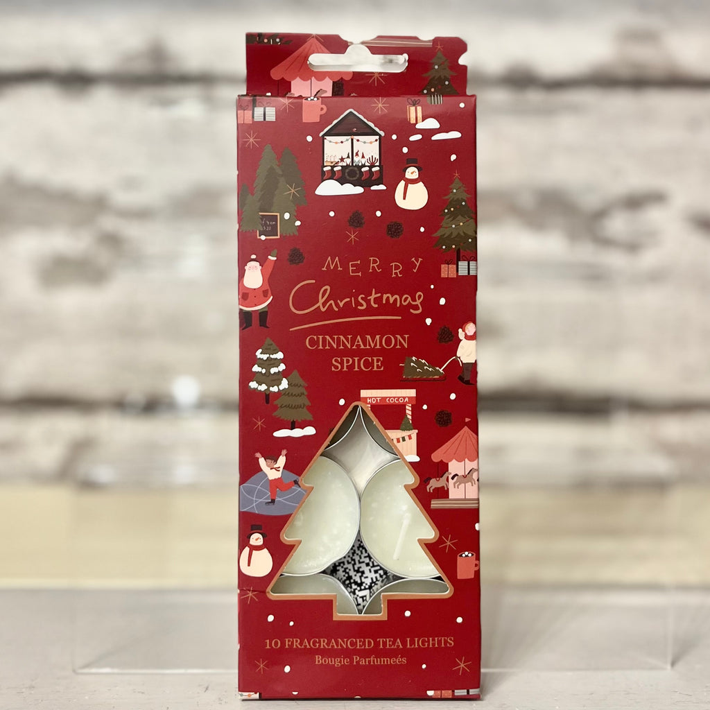 Red Christmas-themed packaging of cinnamon spice tea lights on a wooden surface.