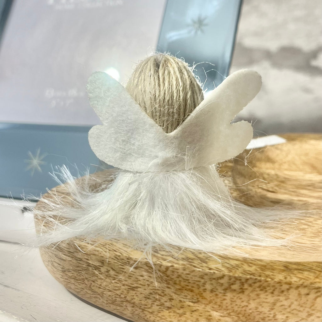Decorative item with white bow and natural elements on a wooden surface