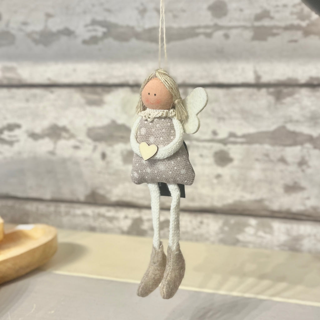 Decorative angel figurine with a heart on a wooden surface