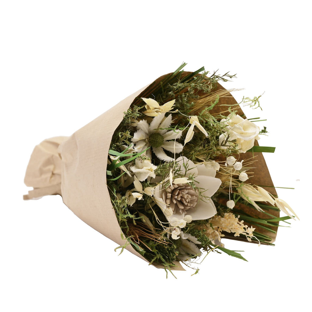 Faux floral bouquet wrapped in brown paper featuring misc leaves and flowers in white and green with one big white flower.