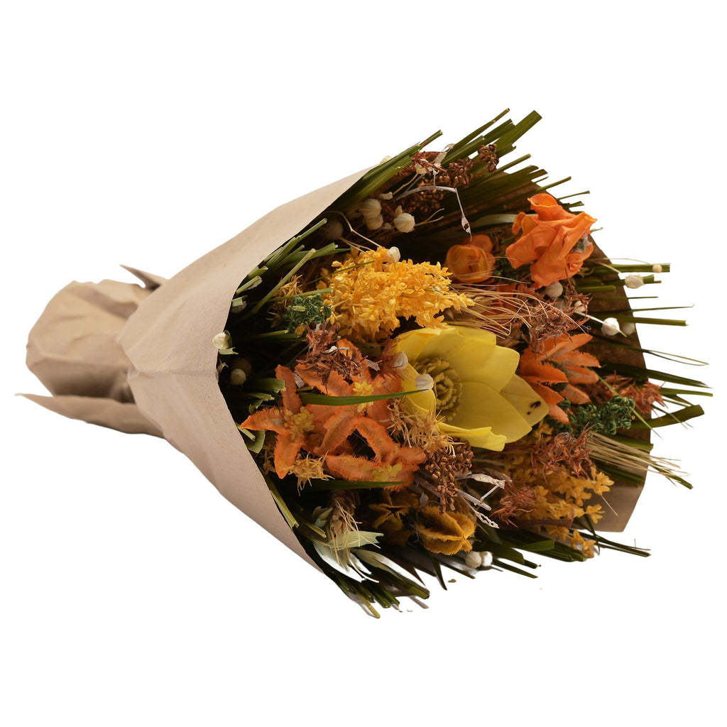 Faux floral bouquet wrapped in brown paper featuring misc leaves and flowers in green, yellow and orange with one big yellow flower.