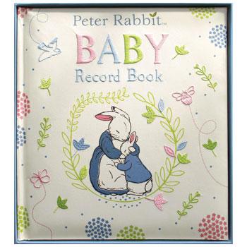 White book with printed and embroidered floral design in pink, blue, and green. Features an illustration of Peter Rabbit and his mother in the middle with 'Baby Record Book' embroidered above. 