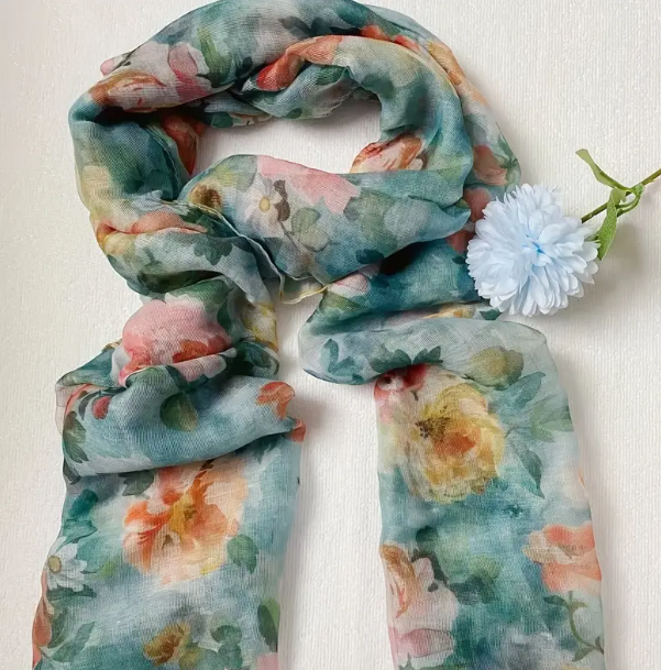 Teal green scarf with watercolour style pink and yellow flower design.