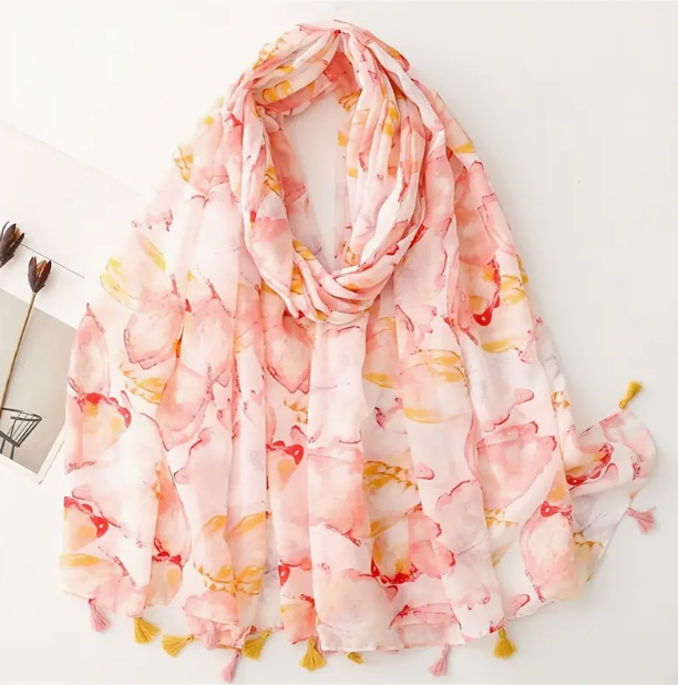 Pink and orange scarf with watercolour butterfly design. Pink and orange alternating tassels on the scarf edge.