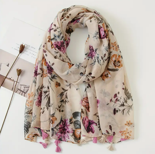 Cream scarf with purple flowers and orange flowers. Tassels on the edge of the scarf alternate in purple and cream colours. 