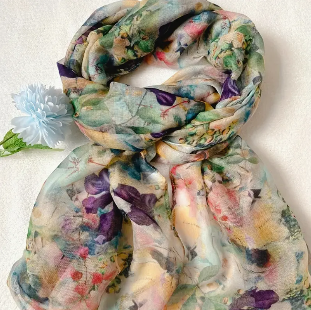 Soft blue/green scarf with bright purple flowers, yellow flowers, and a few pink flowers.