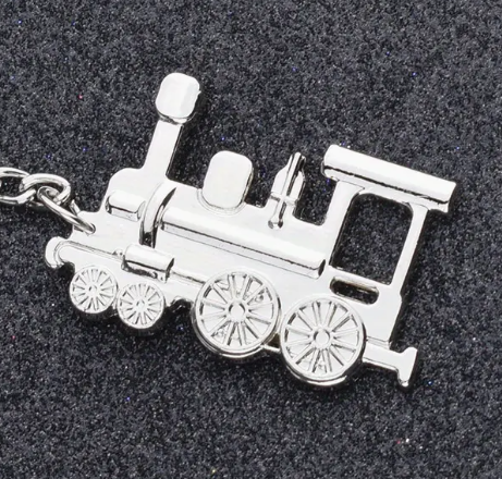 silver train shaped keyring with 'S7DR200' engraved on the back