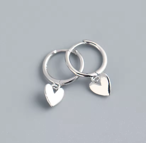 Small silver hoops featuring a dangling heart. 