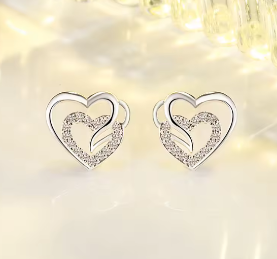 silver stud earrings with a smaller heart made from cubic zirconium intertwined with a larger heart made from sterling silver. 