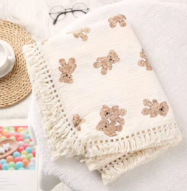 White blanket with teddy bear patterns on a white surface