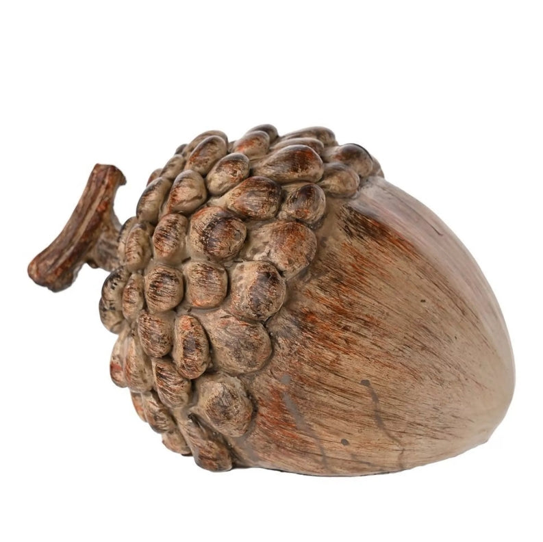 Rustic acorn decoration lying on its side on a white background 