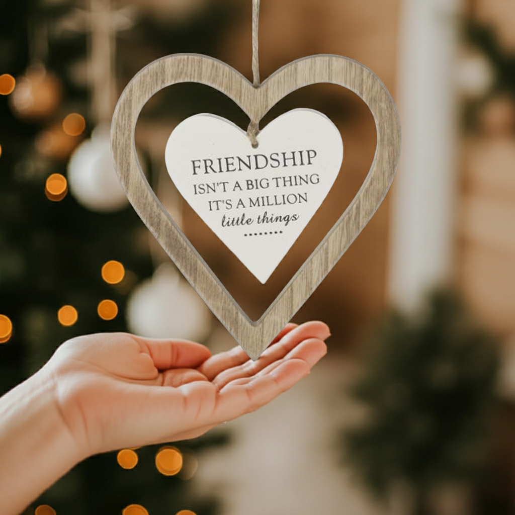 Heart-shaped wooden ornament with a quote on a blurred background