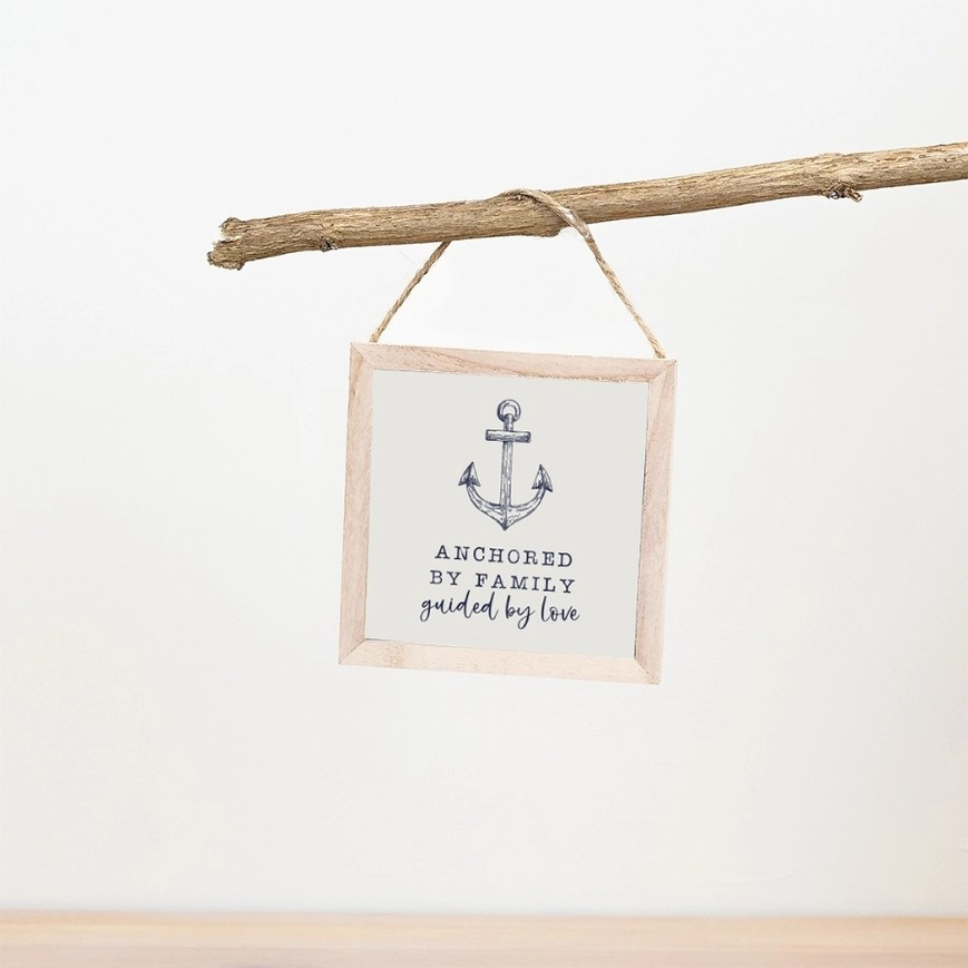 Light wooden frame with twine hanging feature. Features an anchor illustration with the phrase 'Anchored by family, guided by love' underneath